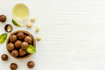 Macadamia nuts oil with raw shelled nuts, top view