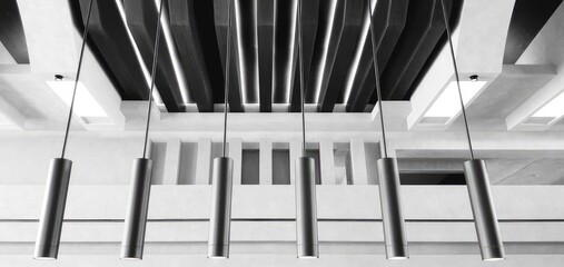 Black and white image of hanging lights in a corporate setting