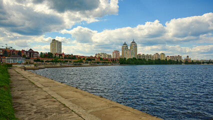 Fototapeta premium Kyiv,Ukraine-July 09,2023:Picturesque panoramic landscape of embankment in the Obolon neighborhood in sunny day. Popular place for recreation among locals and tourists