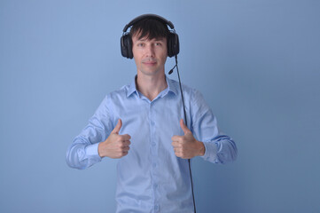 Jovem bonito vestindo suéter casual  sobre fundo azul rosto feliz sorrindo. Pessoa positiva, fones de ouvido