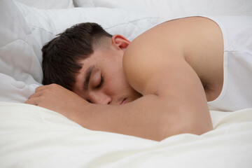 Obraz na płótnie Canvas Young Man Sleeping on Top of Bed