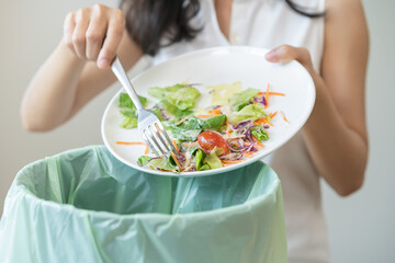Compost from leftover food asian young housekeeper woman, female hand holding salad bowl use fork...