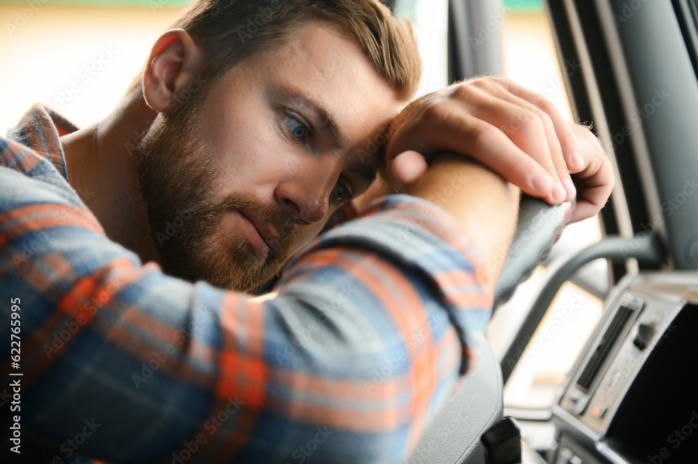 Canvas Prints Young truck diver feeling tired and yawning during the ride.