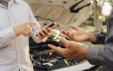 Young mechanic opens the bonnet to inspect the engine for damage and does professional maintenance. He puts on his uniform and inspects.	