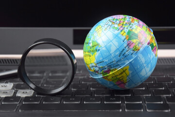 Laptop keyboard with world globe on top.