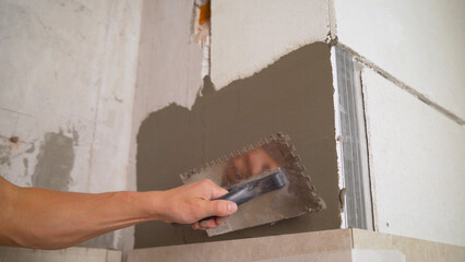 The adhesive solution is applied to the wall. Putty on the wall, for gluing ceramic tiles. Laying...