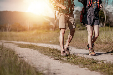 Adventure, travel, tourism, hiker and backpack Concept. Hikers with backpacks walking trough forest path wearing mountain boots with focus on shoes.