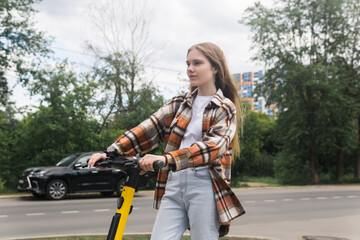 young woman on an electric scooter rides down the street