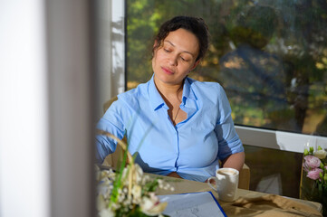Portrait of a multi-ethnic charming pregnant woman designer working on new creative task from home