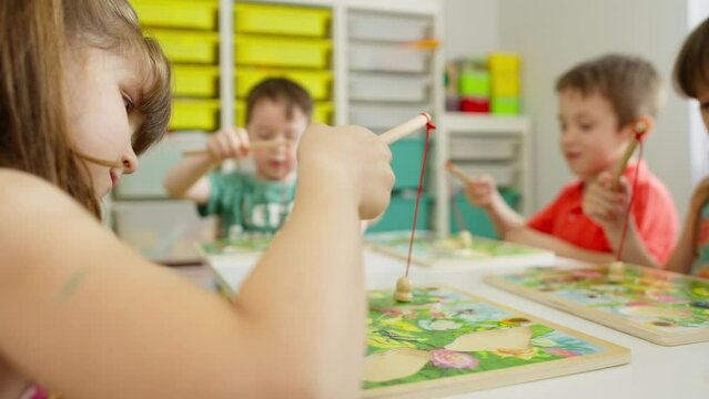 Children learn and play educational games with a teacher in kindergarten. Fun time spent together with friends while studying. High quality 4k footage