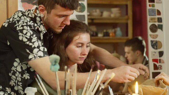 a master ceramist helps a girl sculpt clay at a pottery class. A creative creative hobby of modeling clay by hand. High quality 4k footage