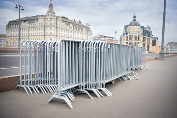 Folded portable temporary fence parts on sidewalk. Preparation for roads and sidewalk closing in...