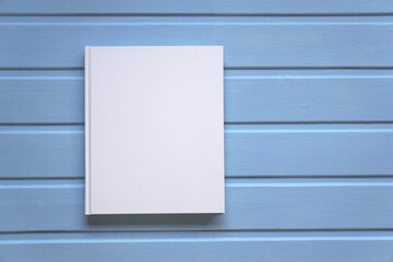 Book mockup. a paper album with a white blank cover on a blue board surface.