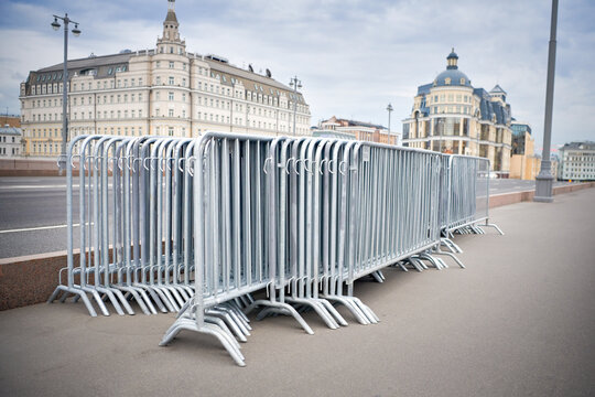 Folded portable temporary fence parts on sidewalk. Preparation for roads and sidewalk closing in case of possible protests or mass events and a large crowd of people.