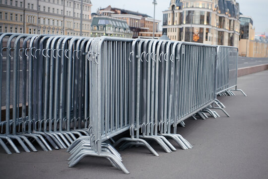 Folded portable temporary fence parts on sidewalk. Preparation for roads and sidewalk closing in case of possible protests or mass events and a large crowd of people.