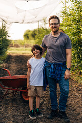 Portrait of a man with his son in the orchard.