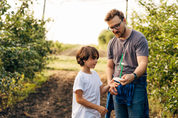A Caucasian man teaches his son about wind energy in nature.
