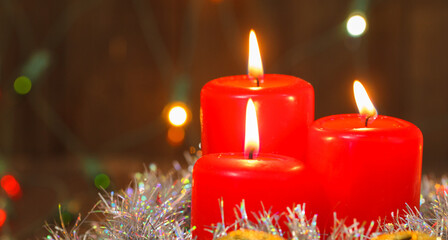 three burning candles and golden balls. christmas background