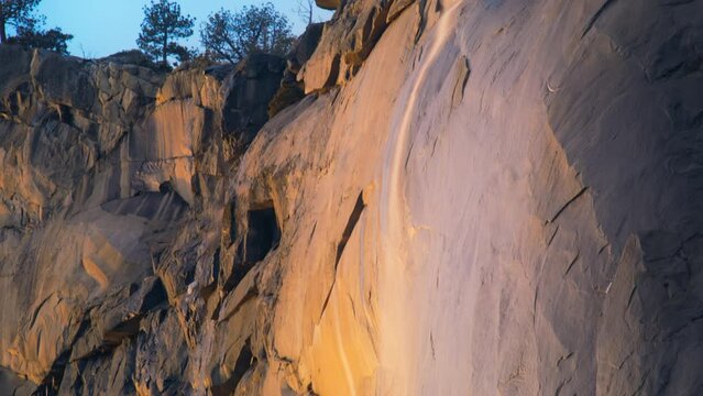 Sunset lights falling on Horsetail fall in Yosemite National Park, California, USA. Yosemite Firefall - rare event in winter season. Amazing waterfall landscape in Yosemite valley. Panning shot in 4k