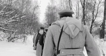 Historical Reenactment of Civil War. Army on Marching. Men Dressed As White Guard Soldiers Of Imperial Russian Army In Russian Civil War s Marching Through Snowy Winter Forest. Black And White Video.