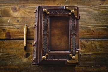 Aged leather book cover, design with embossed ambigram "Memento Mori" as a frame - captured on wooden table