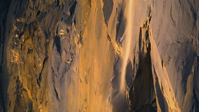 Stunning shot of Yosemite Firefall illuminated by sunset light in Yosemite National Park, California, USA. Panning view of Horsetail fall in winter. Fire fall in Yosemite valley, 4k footage background