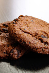 Two cookies with chocolate on wooden table