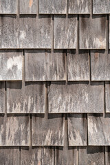 Fototapeta premium Close-up view of large gray weathered shingles on typical Cape Cod building in quaint fishing village on Martha's Vineyard, Massachusetts. 