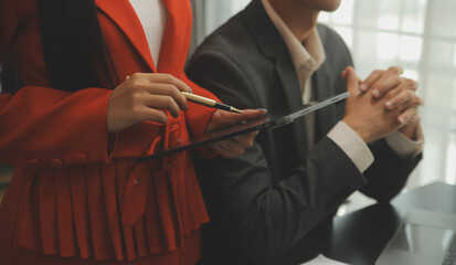 Fototapeta premium Entrepreneur Asian businessman and businesswoman discussing new business project in tablet in modern Meeting In Modern Office, Asian business casual concept.