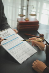 Business and lawyers discussing contract papers with brass scale on desk in office. Law, legal services, advice, justice and law concept picture with film grain effect