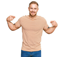 Fototapeta premium Young irish man wearing casual clothes looking confident with smile on face, pointing oneself with fingers proud and happy.