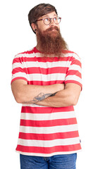 Handsome young red head man with long beard wearing casual clothes smiling looking to the side and staring away thinking.