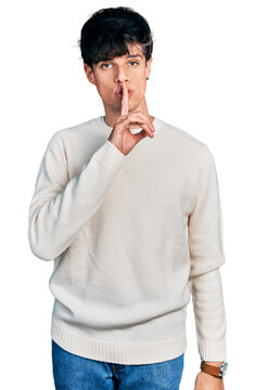 Handsome hipster young man wearing casual winter sweater asking to be quiet with finger on lips. silence and secret concept.