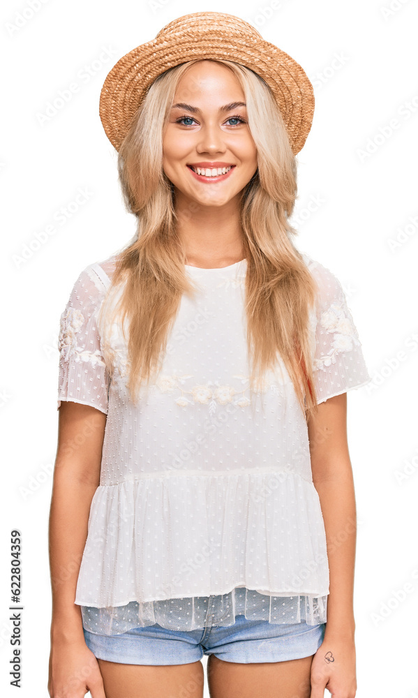 Wall mural Young blonde girl wearing summer hat with a happy and cool smile on face. lucky person.