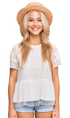 Young blonde girl wearing summer hat with a happy and cool smile on face. lucky person.