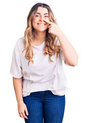 Fototapeta premium Young caucasian woman wearing casual clothes pointing with hand finger to face and nose, smiling cheerful. beauty concept