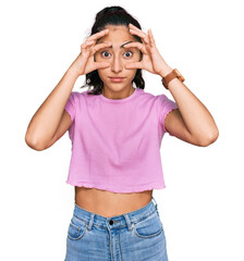 Hispanic teenager girl with dental braces wearing casual clothes trying to open eyes with fingers, sleepy and tired for morning fatigue