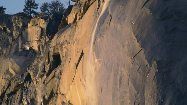 Natural landscape of Yosemite Firefall in winter, Yosemite National Park, California, USA. Panning view of Horsetail fall in Yosemite valley. Stunning waterfall on top of El Capitan rock, 4k footage 