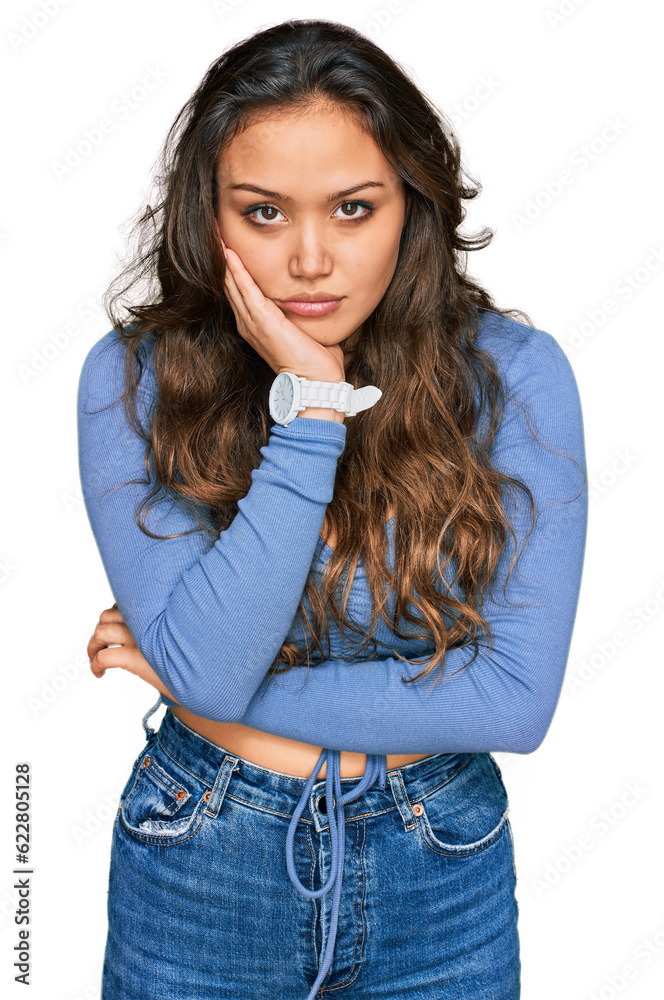 Wall mural Young hispanic girl wearing casual clothes thinking looking tired and bored with depression problems with crossed arms.