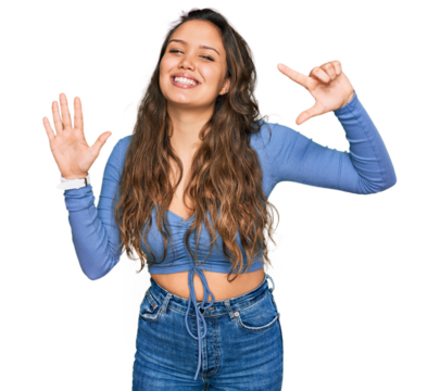 Young hispanic girl wearing casual clothes showing and pointing up with fingers number seven while smiling confident and happy.
