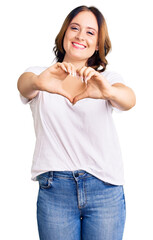 Young beautiful caucasian woman wearing casual white tshirt smiling in love doing heart symbol shape with hands. romantic concept.