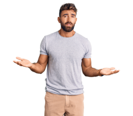 Young hispanic man wearing casual clothes clueless and confused with open arms, no idea concept.