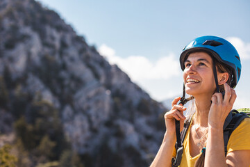 The girl puts on a helmet for mountaineering and climbing. Safety in extreme sports. adventure and...