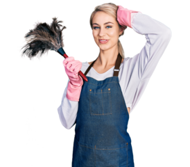 Beautiful young blonde woman wearing apron holding cleaning duster smiling confident touching hair with hand up gesture, posing attractive and fashionable
