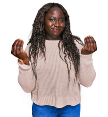 Young african woman wearing wool winter sweater doing money gesture with hands, asking for salary...