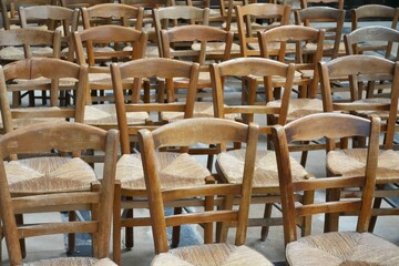 Rows of Wooden Brown Chairs on a stone floor. 