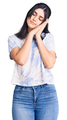 Fototapeta premium Young beautiful girl wearing casual t shirt sleeping tired dreaming and posing with hands together while smiling with closed eyes.