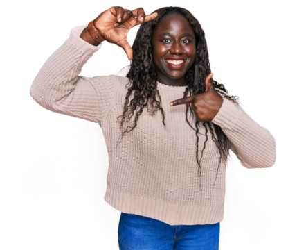 Young african woman wearing wool winter sweater smiling making frame with hands and fingers with happy face. creativity and photography concept.