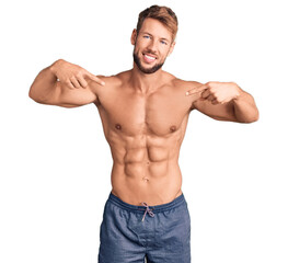 Fototapeta premium Young caucasian man standing shirtless looking confident with smile on face, pointing oneself with fingers proud and happy.