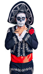 Young man wearing day of the dead costume over background shouting and suffocate because painful strangle. health problem. asphyxiate and suicide concept.